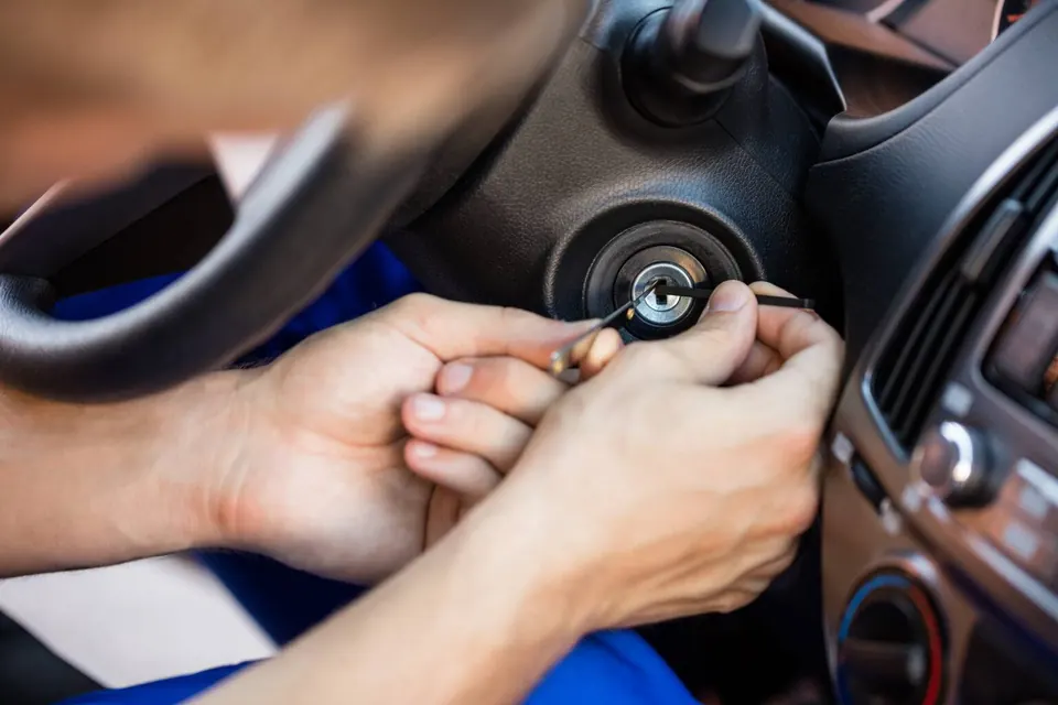 A vehicle ignition lock being examined beside the steering wheel