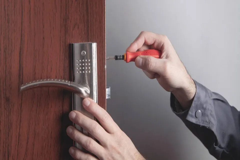 A keypad lever lock being fitted to a wooden commercial door